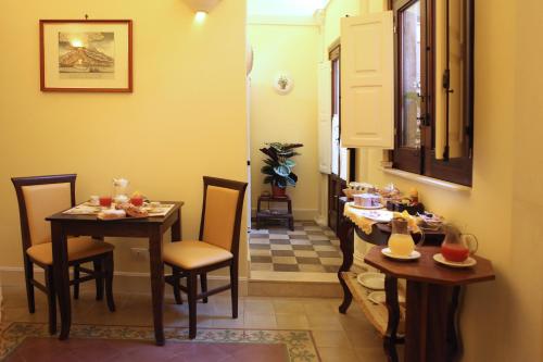 una piccola sala da pranzo con due tavoli e sedie di Al Duomo Inn a Catania