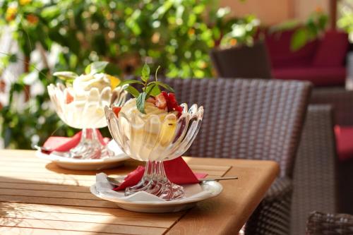 two dishes of ice cream on a wooden table at Alpenhotel Tirolerhof in Fulpmes