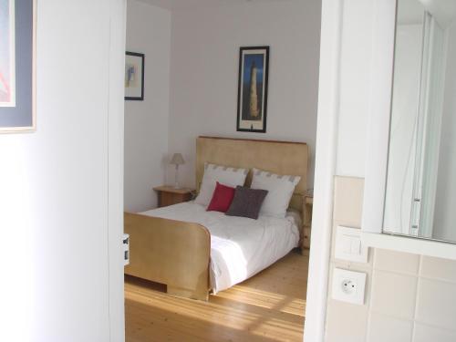 a bedroom with a bed with white sheets and red pillows at Chambres de Condate in Rennes