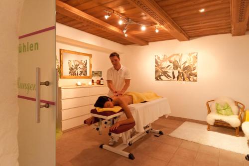 a man standing next to a patient in a hospital bed at Alpenhotel Tirolerhof in Fulpmes
