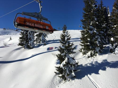 a ski lift flying over a snow covered slope with trees at Villa 7 in Flachau