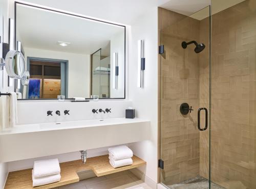 uma casa de banho com um lavatório e um chuveiro em Limelight Hotel Snowmass em Snowmass Village