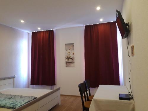 a bedroom with two beds and a red curtain at Trang Hotel-Restaurant in Rastatt