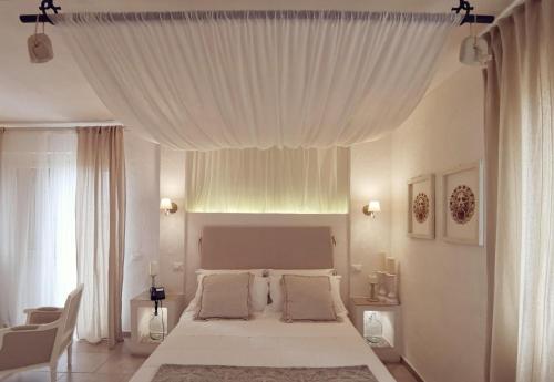 a bedroom with a large bed with a white canopy at Le Nicchie Guest House in Lucera