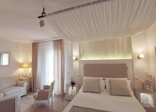 a white bedroom with a white bed and a couch at Le Nicchie Guest House in Lucera