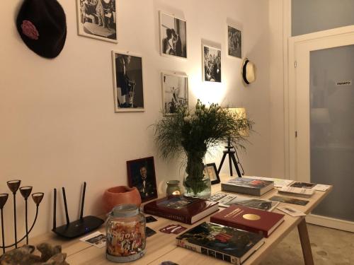 una habitación con una mesa con fotos y fotografías en la pared en Guest House Ca' Lou al Teatro, en Vicenza