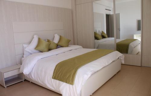 a bedroom with a large white bed with green pillows at RESIDENCE TOURISTIQUE DU PORT in Alger
