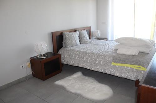 ヴィラ・レアル・デ・サント・アントニオにあるRias Apartのベッドルーム(ベッド1台、テレビ、ラグ付)
