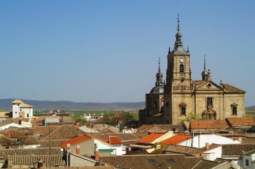 an old church with a clock tower in a town at La Rosaleda de Orgaz in Orgaz