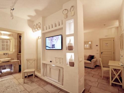 a living room with a tv on a wall at Le Nicchie Guest House in Lucera