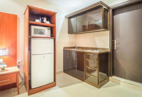 a kitchen with a sink and a refrigerator at Al Muhaidb Al Takhassosi Abaqrino in Riyadh