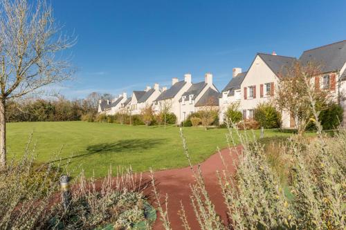 a row of houses with a lawn in front at Résidence Pierre & Vacances le Green Beach in Port-en-Bessin-Huppain