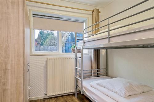 a bedroom with two bunk beds and a window at Sfeervol 6 persoons appartement - van alle gemakken voorzien! in Bakkeveen