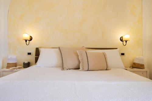a bed with white sheets and pillows in a bedroom at Le Gioie - Villa Macchia Mediterranea - Splendida villa vista mare immersa nel verde in Torre Pali 