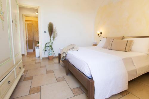 a bedroom with a large bed and a tiled floor at Le Gioie - Villa Macchia Mediterranea - Splendida villa vista mare immersa nel verde in Torre Pali 