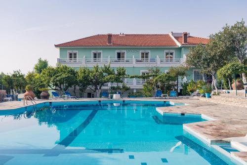 a swimming pool with a house in the background at Evelin hotel in Pythagoreio