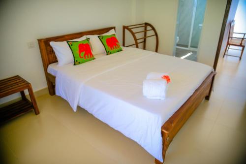 a bedroom with a white bed with a box on it at White Lodge in Kandy
