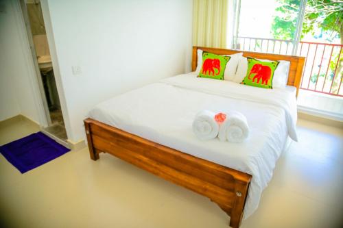 a bedroom with a bed with two towels at White Lodge in Kandy