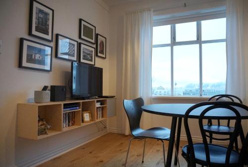 a living room with a table and a tv and a window at Nest Apartments in Reykjavík