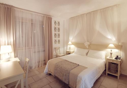 a bedroom with a bed and two tables and two lamps at Le Nicchie Guest House in Lucera