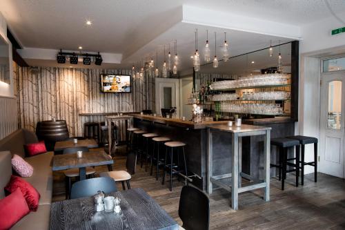 a restaurant with a bar and some tables and chairs at Wallner - Hotel & Wirt in Arnoldstein