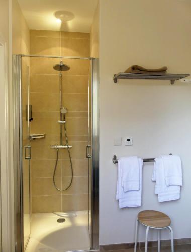 a shower in a bathroom with white towels on a wall at Les Ambaciales in Amboise