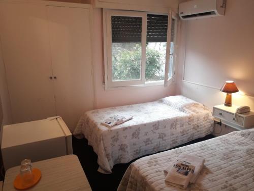 a small room with two beds and a window at Alpes Hotel in Punta del Este