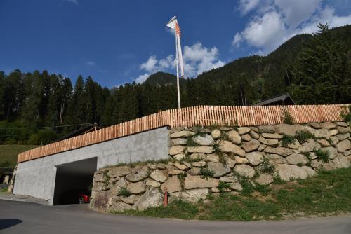 a stone building with a flag on top of it at Pension Gasthof Haselstaude in San Leonardo in Passiria