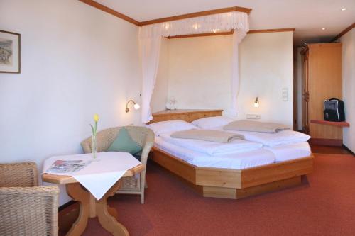 sypialnia z 2 łóżkami, stołem i krzesłami w obiekcie Hotel Adler Bärental w mieście Feldberg