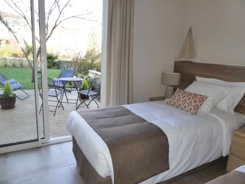 a bedroom with a bed and a view of a patio at Chambres D'hôtes Les Ambaciales in Amboise
