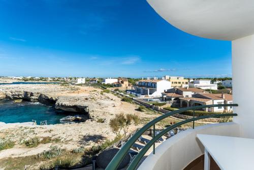 einen Balkon mit Blick auf das Meer und die Gebäude in der Unterkunft Apartamentos Sol Ponent in Cala Blanca