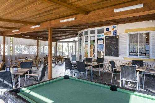 a pool table on the deck of a restaurant at Apartamentos Sol Ponent in Cala Blanca