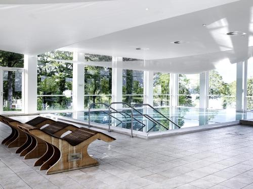 a lobby with a bench in a building with windows at Comwell Kellers Park in Brejning