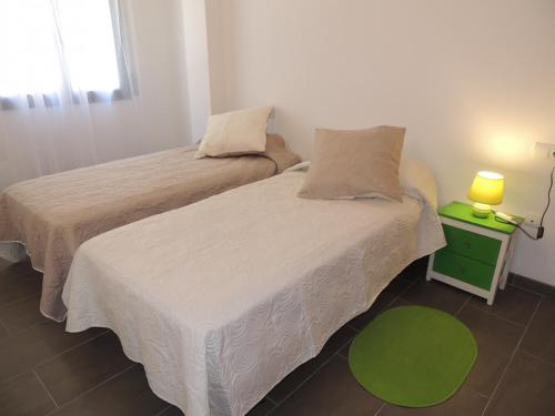 twee bedden in een kamer met een groene nachtkastje bij Mimosas 2 C Empuriabrava Gran Reserva - Immo Barneda in Empuriabrava