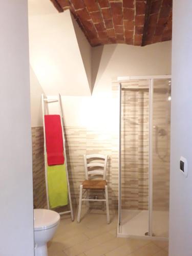 a bathroom with a toilet and a chair at Bed and Breakfast Ca D'Pandin in Peveragno