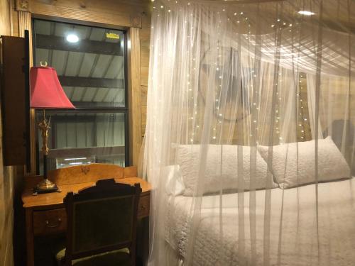 a bedroom with a canopy bed with a desk and a window at The Barn Loft in Tyler