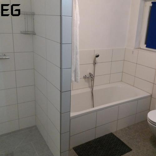 a bathroom with a tub and a toilet at Apartment am Golfplatz in Brochthausen
