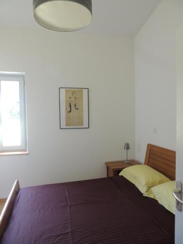 een slaapkamer met een bed en een raam bij La Ferme des Buis in Mercurol