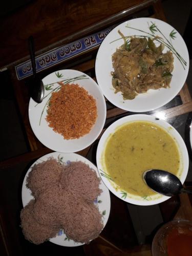 a table with four plates of food and a bowl of soup at Bisandu guesthouse in Mirissa