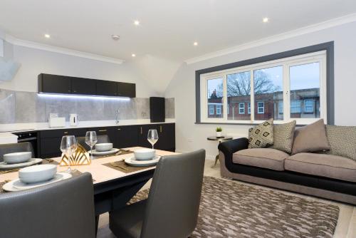 a kitchen and living room with a table and a couch at Amazing Apartment near Bournemouth, Poole & Sandbanks - WiFi & Smart TV - Newly Renovated! Great Location! in Poole