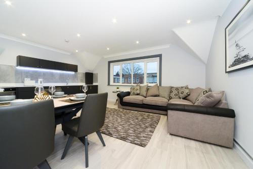 a living room with a couch and a table at Amazing Apartment near Bournemouth, Poole & Sandbanks - WiFi & Smart TV - Newly Renovated! Great Location! in Poole