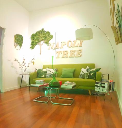 a living room with a green couch and a table at Napoli Tree - Lungomare in Naples