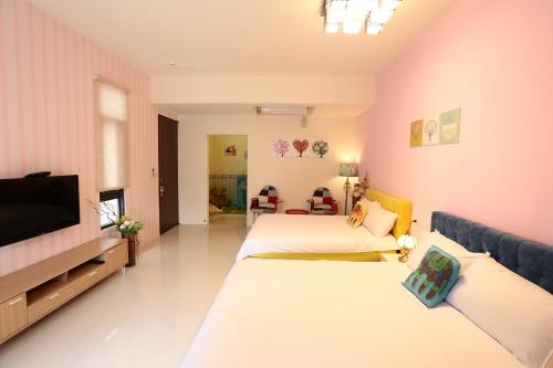 a room with two beds and a flat screen tv at 花蓮168電梯民宿-可包棟 in Jian