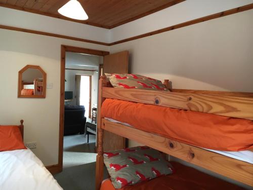 a bedroom with two bunk beds and a mirror at Muckross School House in Kilcar