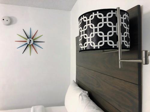a bedroom with a headboard and a clock on the wall at Beach House Dewey in Dewey Beach