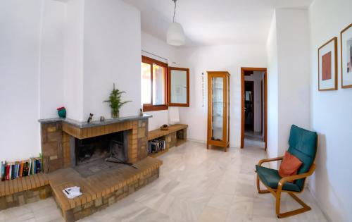 a living room with a fireplace and a chair at Terra Ionian in Áyios Ilías