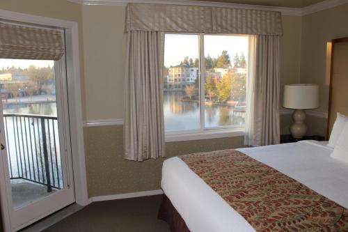 a bedroom with a bed and two large windows at Century Hotel in Tualatin