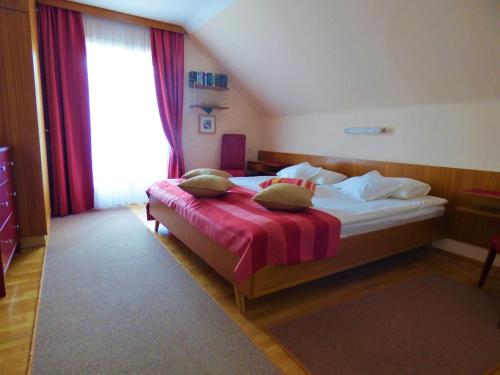 sypialnia z łóżkiem i dużym oknem w obiekcie Haus Thon w mieście Bodensdorf