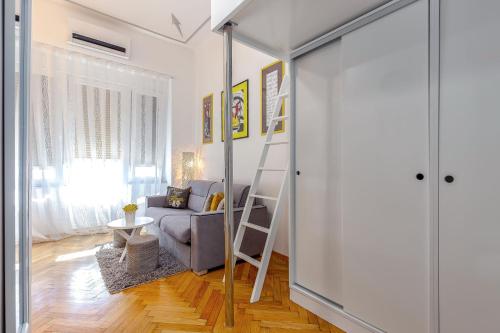 a living room with a loft bed and a couch at Studio apartman Piramida in Rijeka