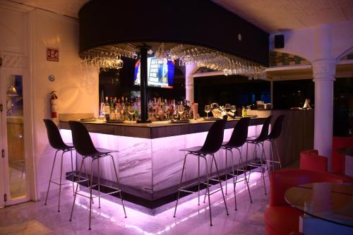 a bar with a row of stools in a restaurant at Villa Bejar Cuernavaca in Cuernavaca